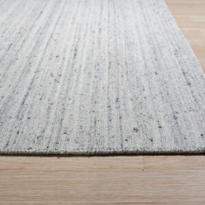 Close-up of a low-pile gray speckled rug with faint vertical stripes on light wood planks.