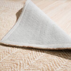 Beige and cream high-pile rug showing a chevron pattern and gray backing on light wood plank flooring.