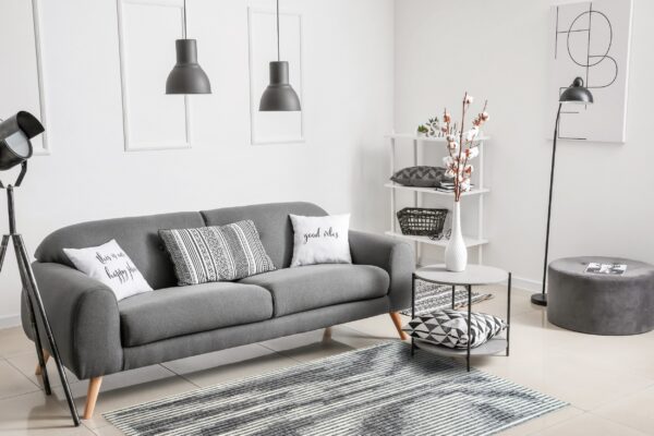 Horizontal gray and white striped rug under a charcoal sofa in a bright modern living room.