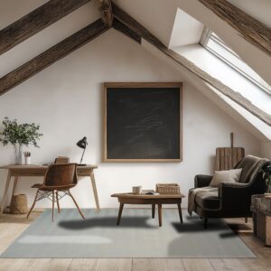 A pale gray rug covers wood flooring in an attic room furnished with a desk and dark armchair.