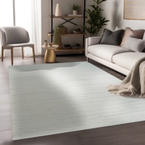 A pale low-pile rug with subtle broken stripe patterning lies on dark wood flooring.