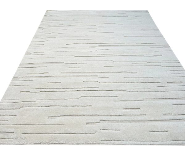 Textured cream-colored rug featuring abstract broken horizontal lines against a white backdrop.