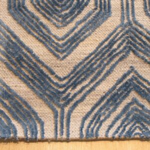 A beige rug features a raised blue textured chevron pattern on light hardwood flooring.