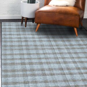 Textured blue and gray plaid rug beneath a brown leather chair on dark wood floors.