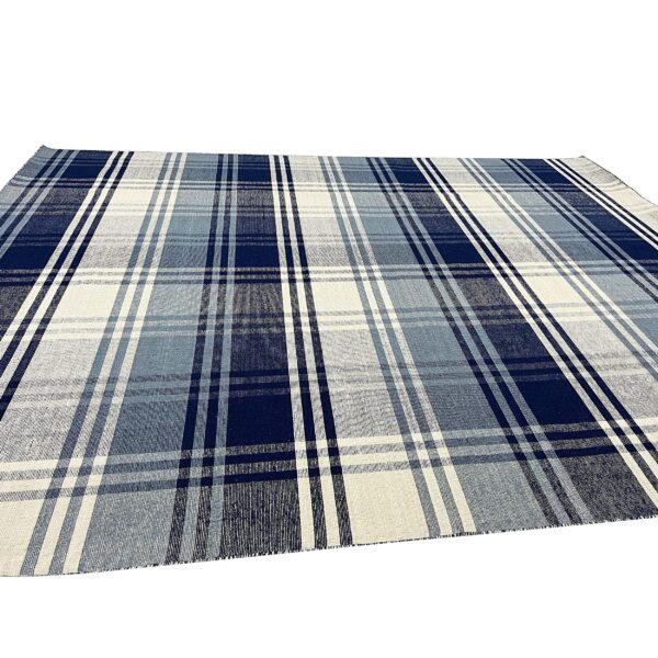 Woven plaid rug displaying shades of navy, medium blue, and cream in a flat texture.