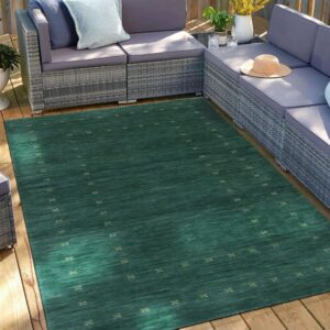 Dark teal rug with small beige repeating motifs sits on a wood deck under gray patio furniture.