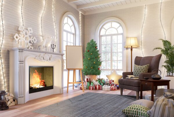 Textured blue-gray rug grounds a christmas living room with a fireplace and tall arched windows.