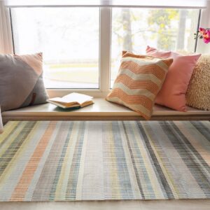 Multicolor striped rug in yellow, orange, blue, and gray sits under a sunny window seat.