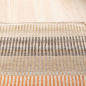 Low-pile rug with vertical stripes creating horizontal color blocks in brown, orange, and neutrals on wood flooring.