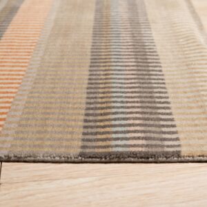 Low-angle view of a striped tan, orange, and grey rug with segmented lines on wood floors.