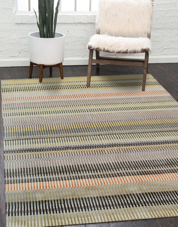 Multicolor striped rug in yellow, gray, orange, and blue rests on dark wood floors near a furry chair.
