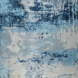 Abstract rug displaying distressed patterns of deep blue, light blue, and textured gray-beige.