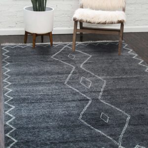 Charcoal rug with white zig-zag and diamond patterns placed under a white shaggy wooden chair.