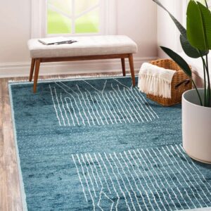 Teal blue rug with abstract white vertical stripes and speckles on wood floors near a window bench.