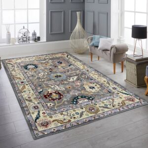 Multicolor traditional floral rug with a gray field and cream border on light gray plank flooring.