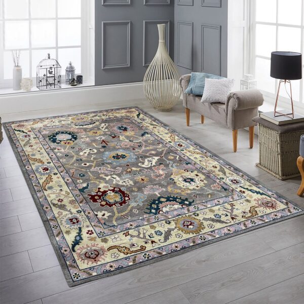 Multicolor traditional floral rug with a gray field and cream border on light gray plank flooring.