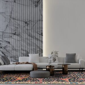 A dark navy traditional rug with red and yellow accents anchors a modern living room with a white sofa and marble wall.
