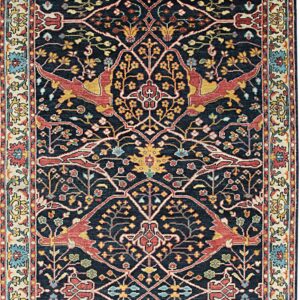 Navy blue rug featuring intricate red, yellow, and blue animal and floral motifs within a cream border.