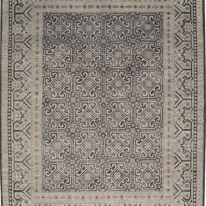 Full view of a low-pile rug with complex gray and beige interlocking geometric patterns and wide borders.
