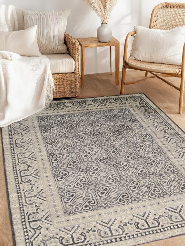 Gray and light beige geometric rug in a bright room with natural wood flooring and wicker furniture.