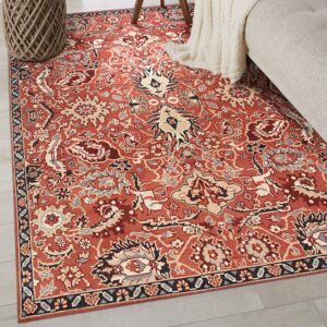 A rust-colored traditional rug with complex patterns in beige, gray, and black rests on light gray floors.