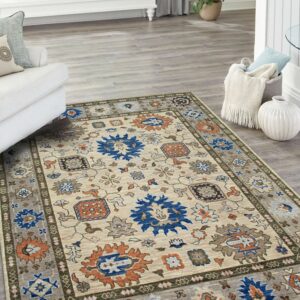 Beige traditional rug featuring dark blue and orange medallions and gray borders on light plank flooring.