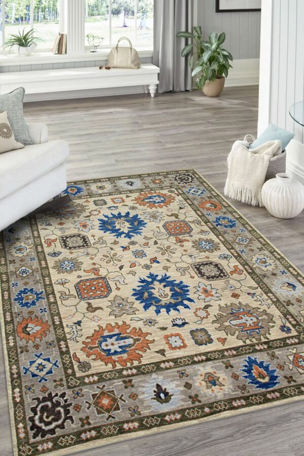 Beige traditional rug featuring dark blue and orange medallions and gray borders on light plank flooring.