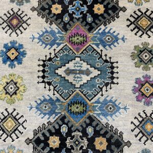 Textured rug detail featuring blue, black, yellow, and purple tribal patterns on a light gray field.