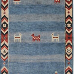 Blue abrash rug with folk figures and a thick geometric border in red, cream, and dark blue.