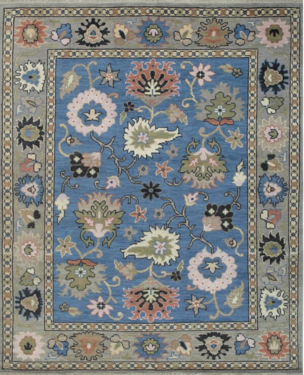 Blue and gray rug featuring a stylized floral pattern in pink, green, and coral accents.