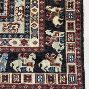 Navy and red traditional rug with borders of geometric and stylized human and animal figures.