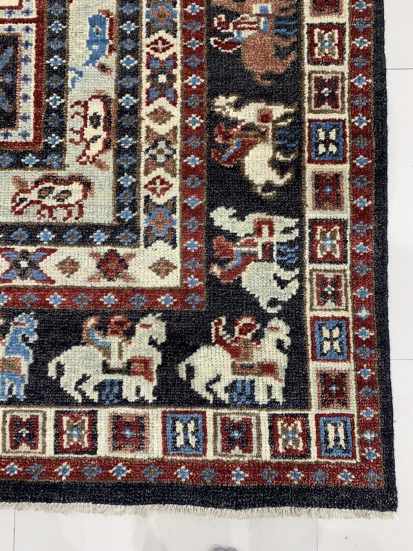 Willow oriental charcoal hand knotted wool rug 4 Navy and red traditional rug with borders of geometric and stylized human and animal figures.