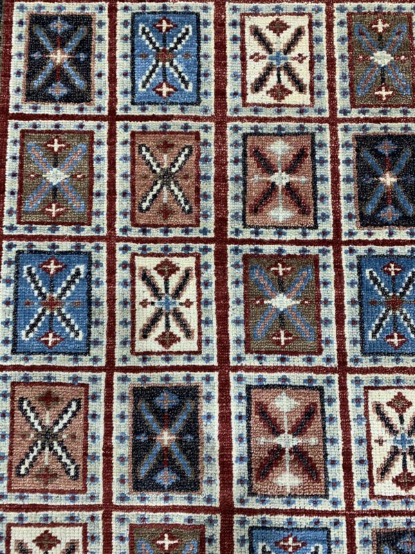 Willow oriental charcoal hand knotted wool rug 3 Repeating grid pattern rug featuring geometric motifs in navy, bright blue, red, brown, and cream colors.