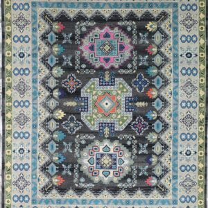 Dark gray rug with high-contrast geometric medallions and borders in blue, pink, light gray, and green.