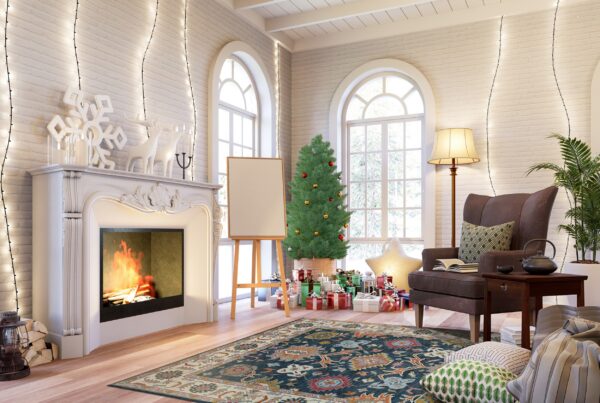 Traditional blue and rust area rug anchors a holiday living room with a fireplace and christmas decorations.
