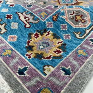 A textured rug corner displays gray, blue, and purple borders with multi-colored geometric and floral motifs.