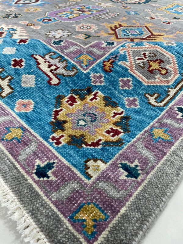 A textured rug corner displays gray, blue, and purple borders with multi-colored geometric and floral motifs.