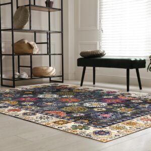 Dark blue rug with bright multicolored geometric medallions and a cream border anchors a bright room.