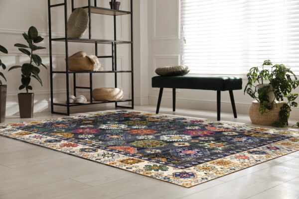 Dark blue rug with bright multicolored geometric medallions and a cream border anchors a bright room.