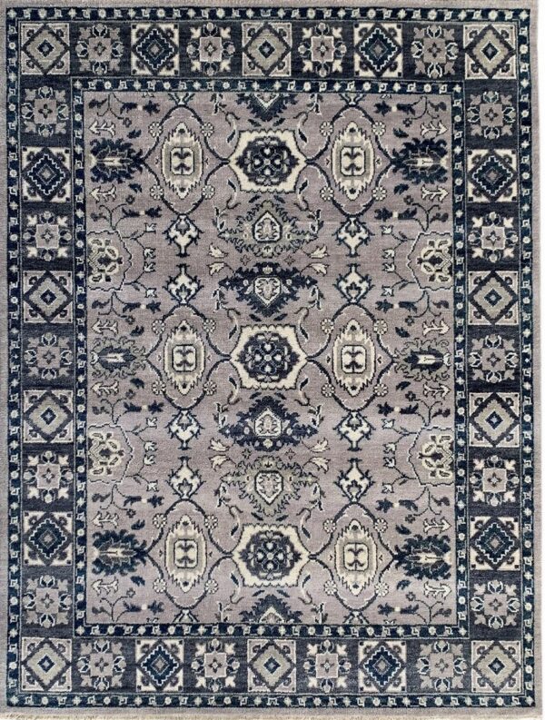 Ornate traditional rug with a gray-purple field, navy blue medallion, and geometric border patterns.