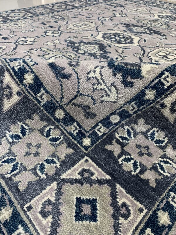 Close-up of a high-pile rug in lavender and navy, featuring intricate floral and geometric patterns.