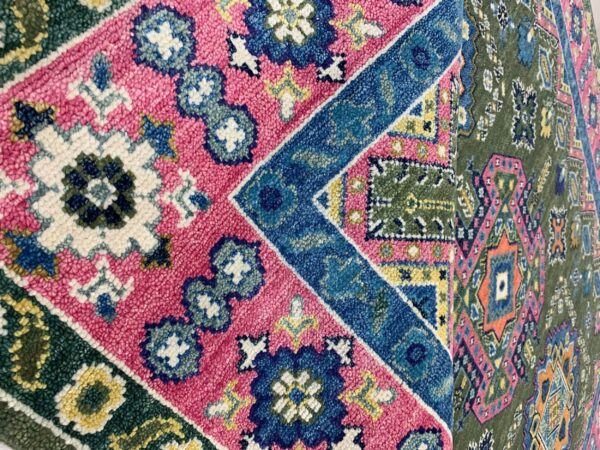Vibrant high-pile rug with complex geometric patterns in fuchsia, blue, green, and cream colors.