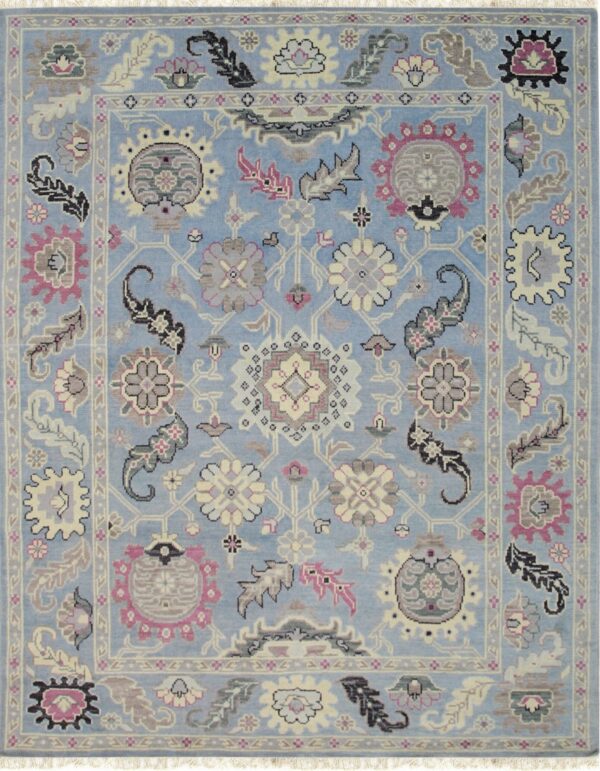 Ornate traditional rug with a light blue field and dense floral motifs in pink, gray, and cream.