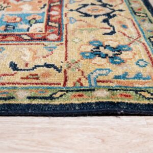 Medium pile rug with traditional yellow, red, blue, and green motifs resting on light wood flooring.