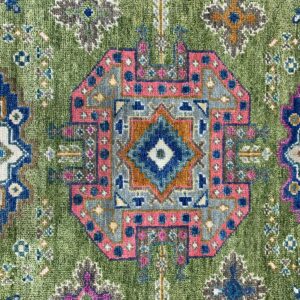 Green textured rug detail with a geometric medallion pattern in pink, blue, gray, and rust colors.