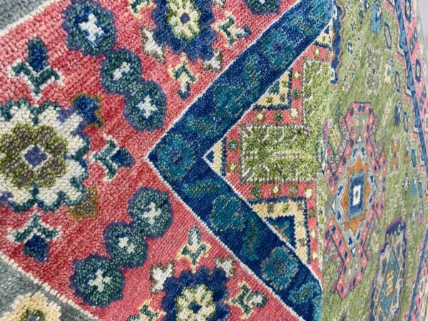 High-pile rug featuring bold geometric patterns in contrasting pink, royal blue, and olive green.