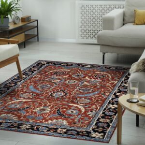 Rust-colored traditional pattern rug grounds a bright room with light gray seating and wood furniture.