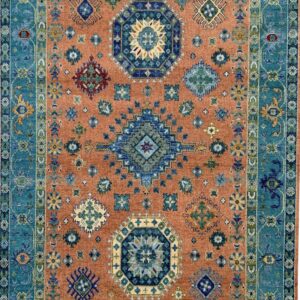 Traditional blue and teal border surrounds a rust field densely patterned with scattered geometric motifs.