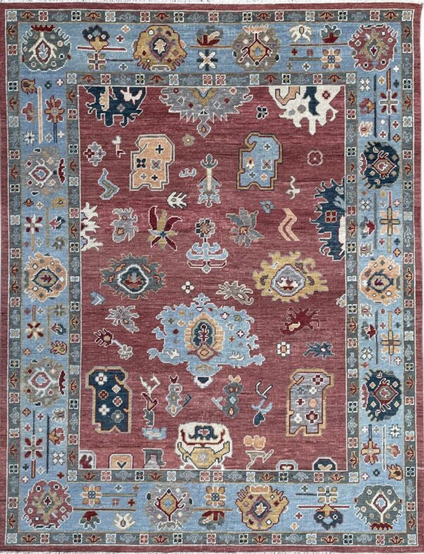 Rust-colored rug with blue and gray stylized motifs and a wide, light blue patterned border.