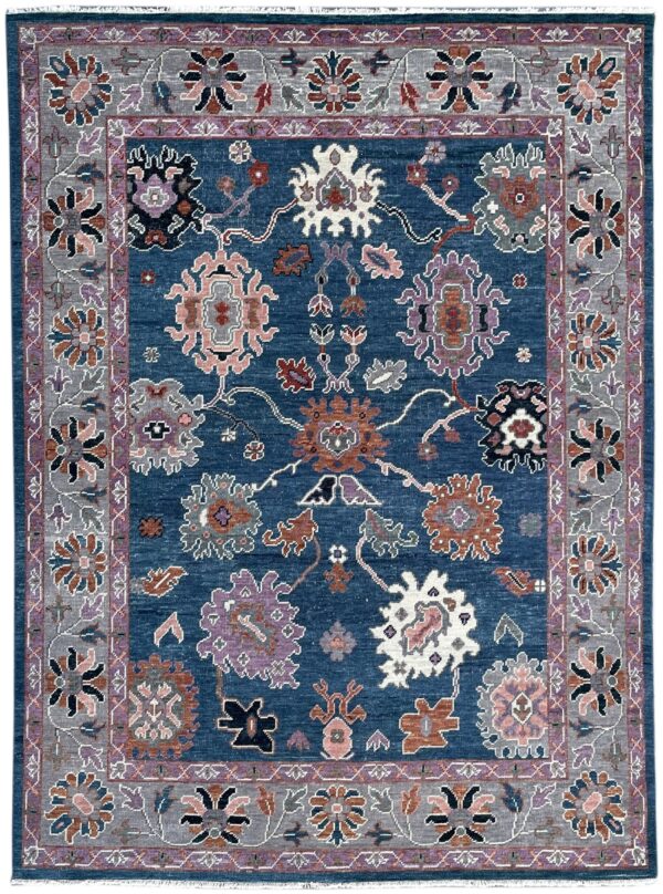 Stylized floral rug with a deep blue field and a gray border, accented by pink, purple, and rust motifs.